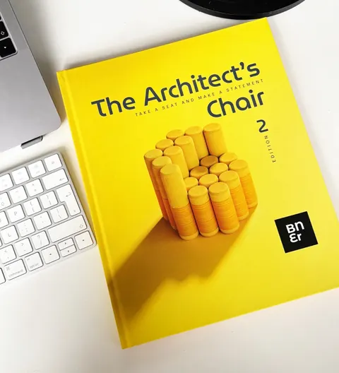 The yellow Architect’s Chair 02 on a white desk beside a keyboard