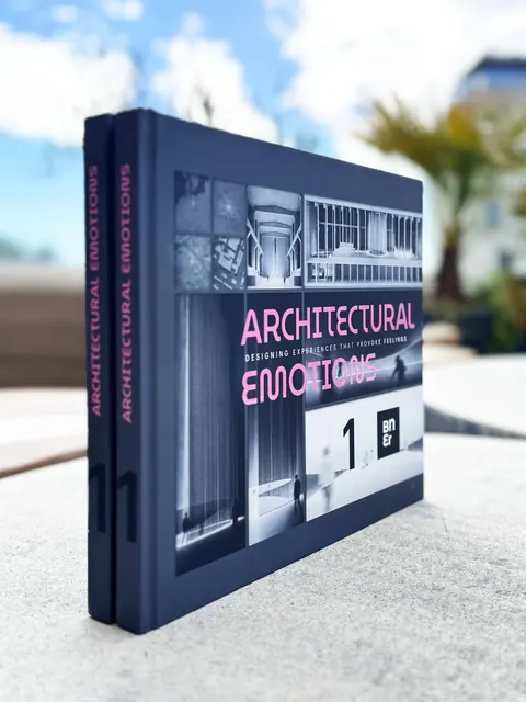 Il libro in piedi su un tavolo di pietra all’aperto, il dorso rosa e la copertina scura al sole