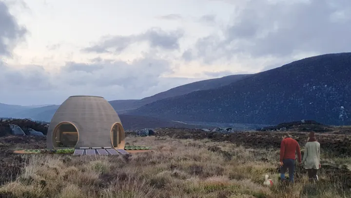 The round, ribbed earth shell on an Irish hillside of heather, two people walking towards it