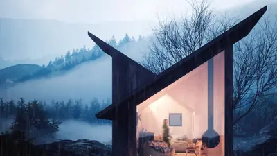 A black timber shelter with a folded roof, warm light inside, in misty blue mountains