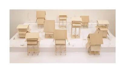 Wooden models of houses raised on stilts, on a white base