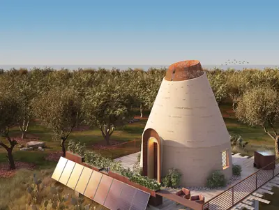 A cone-shaped earth house among olive trees, solar panels on the ground in front