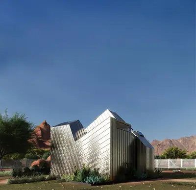 The faceted, metal-clad Pocket House under a deep blue sky, a white picket fence behind