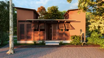A house of red earth walls and timber shutters under two sloping roofs, lit by low sun