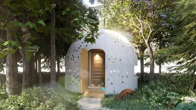 A white dome studded with glass bottles in a wood, a timber door lit from inside