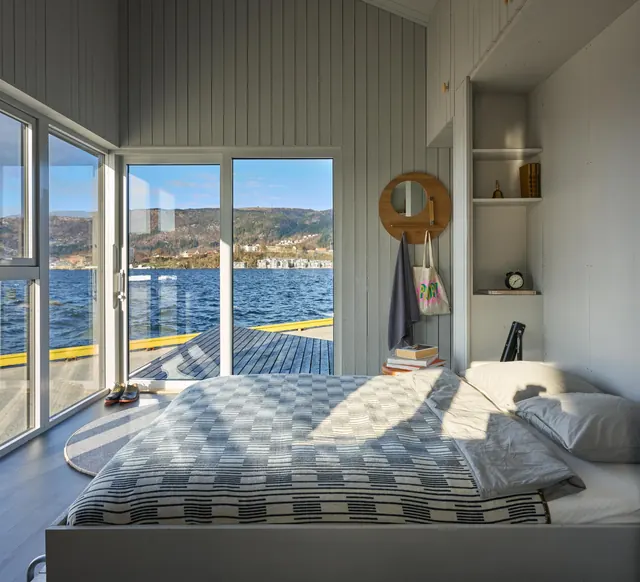 The bed by the big sliding doors, the harbour and hills outside