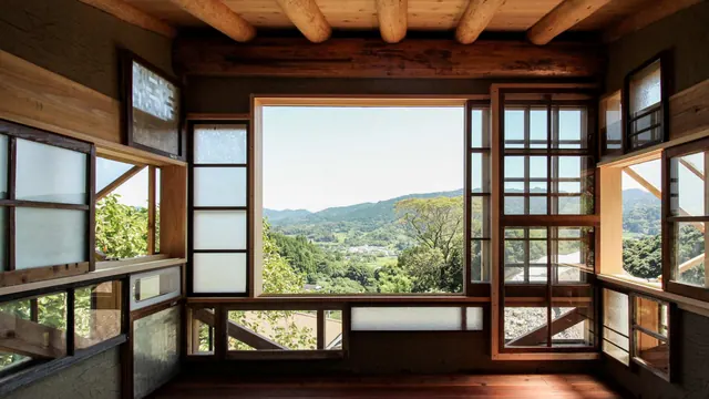 Inside: old wooden windows of many sizes around a wide opening onto green hills and the village