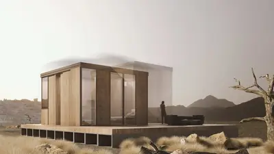 A timber box of glass and slats on a deck in a dry landscape under a pale sky