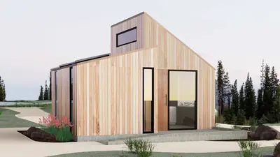 A pale timber house with a steep gabled roof and big windows by a garden