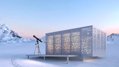 A white box with a pattern of small openings glowing on a snowy plateau, a telescope beside it