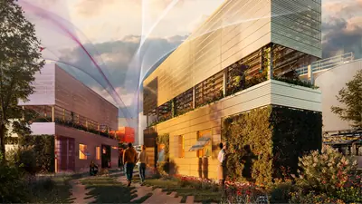 Homes of perforated metal and planted walls along a path at sunset, people walking