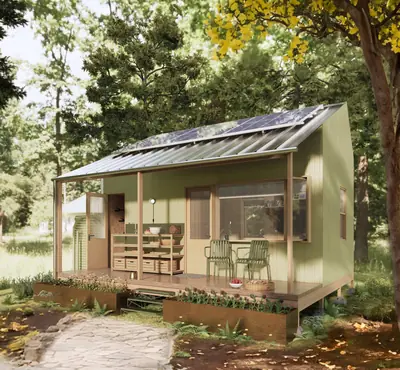 A small pale green house with a porch and solar panels in a garden