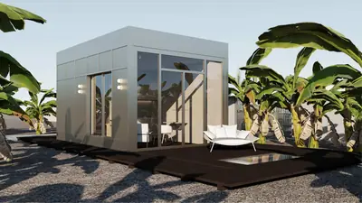 A white box house with a glass front on a dark deck, banana plants around it