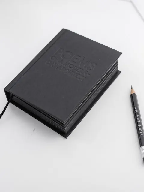 The closed notebook from above, its black ribbon and the black pencil beside it