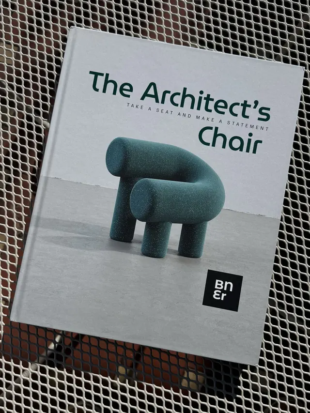 The Architect’s Chair 01 lying on a white metal table in the sun
