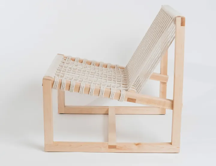 A Lounge Chair in pale wood with a woven rope seat