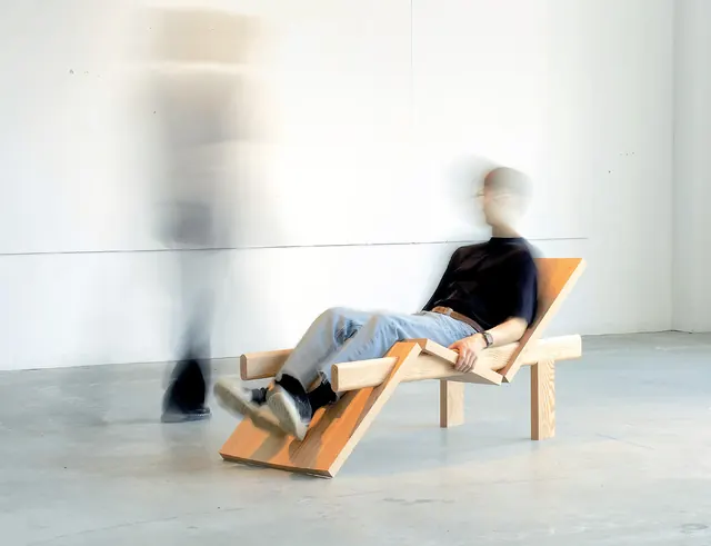 A person reclining on the Brochette lounge chair