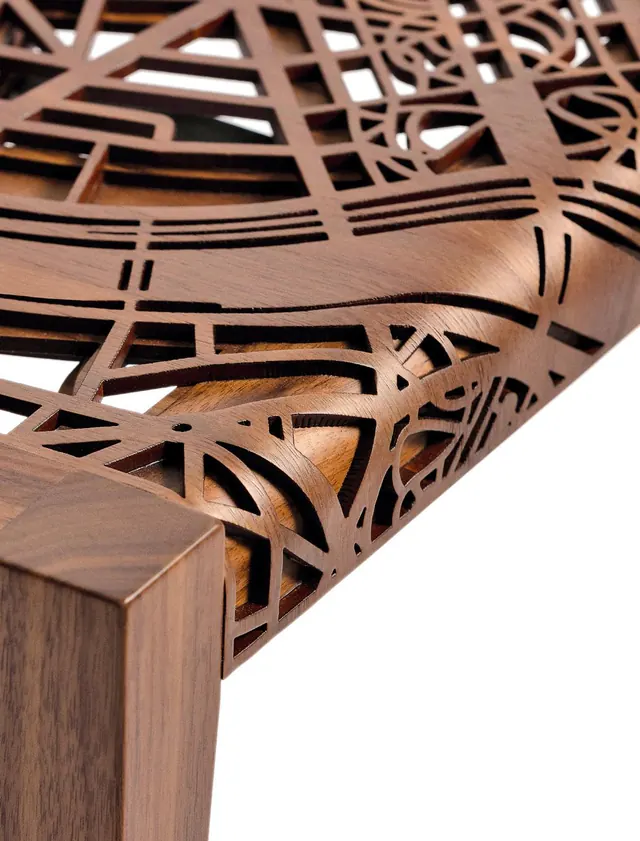 Close-up of the laser-cut plywood map layers in the walnut frame