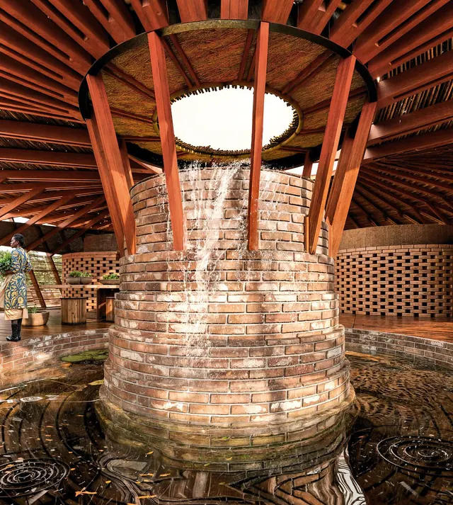 Dans le pavillon : une citerne ronde en briques sous un puits de lumière, la charpente en bois tout autour
