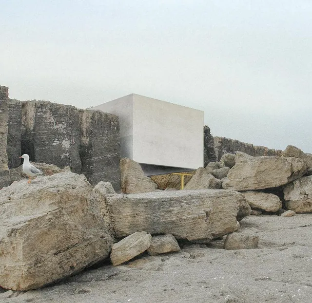 La chapelle, un bloc clair, parmi les rochers brisés de la carrière, une mouette au premier plan