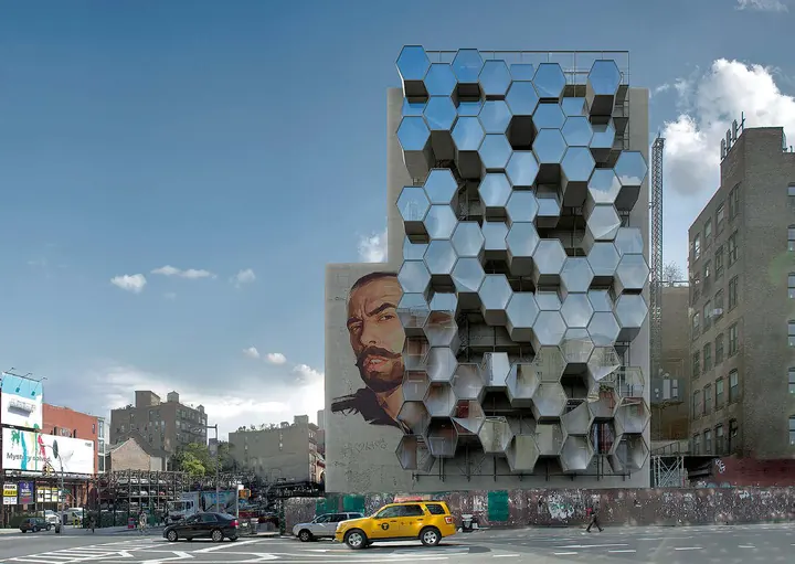 A honeycomb of mirrored hexagonal pods on the blank side wall of a New York building, a yellow cab below