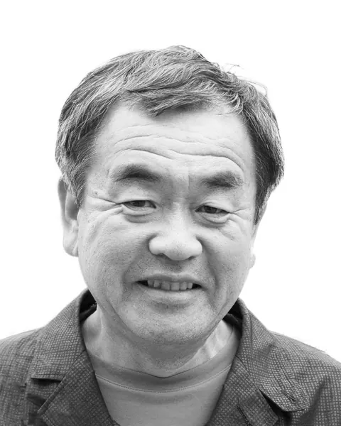 Portrait of Kengo Kuma, smiling, in black and white