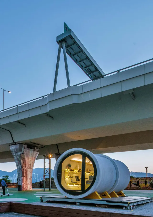 An OPod, a concrete pipe with a round glass end, on a deck under the flyover