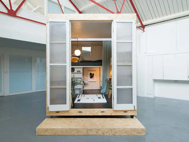 The Shed with its doors open in an empty white hall