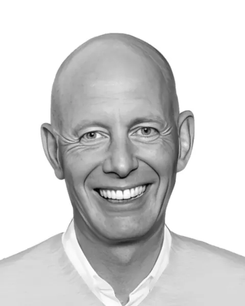 Portrait of Ben van Berkel, smiling, in black and white
