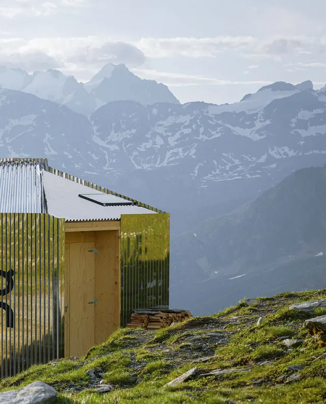 El refugio frente a cumbres alpinas nevadas