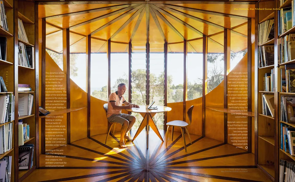 Un hombre ante una mesa redonda en una sala de madera forrada de libros, con una ventana alta que da a los árboles