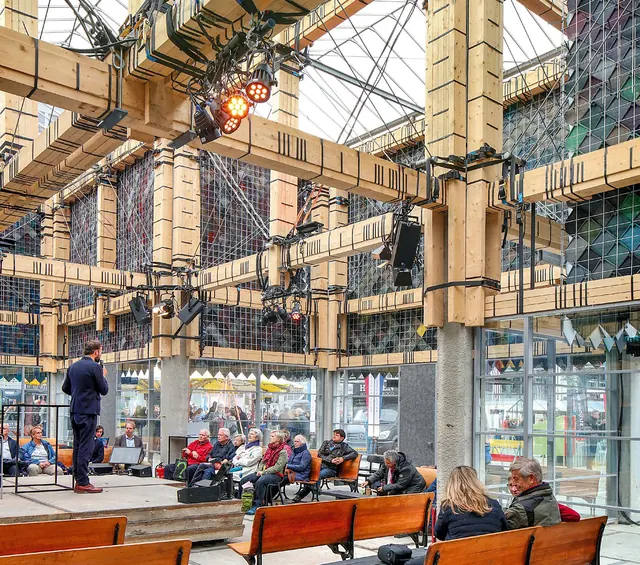 A talk inside under the timber frame, the audience on long benches